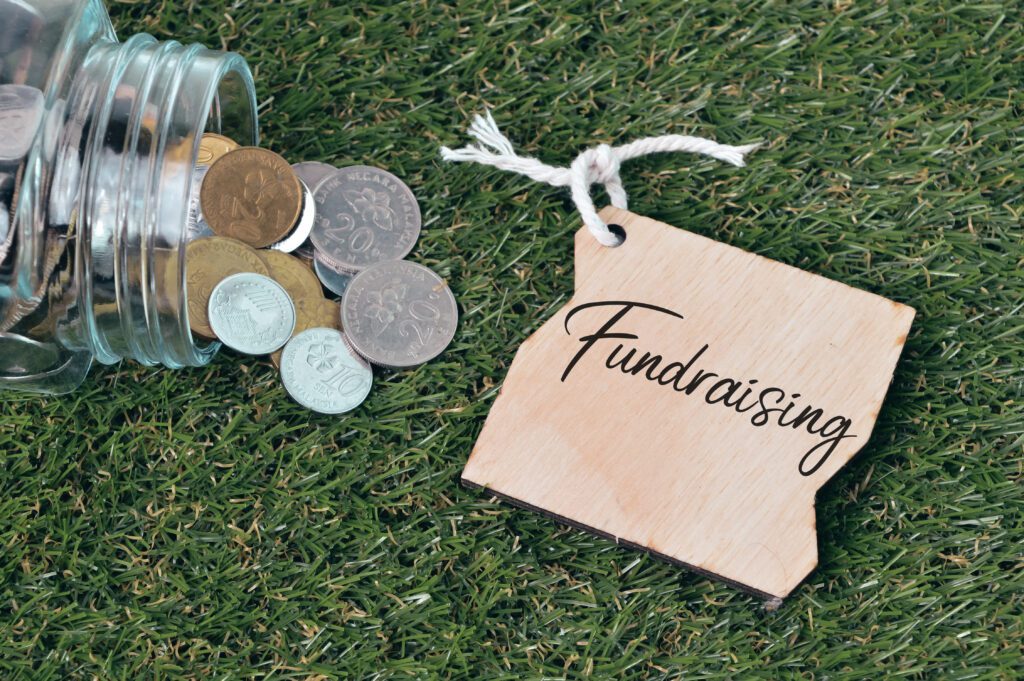 Top view of coins and wooden tag written with FUNDRAISING.